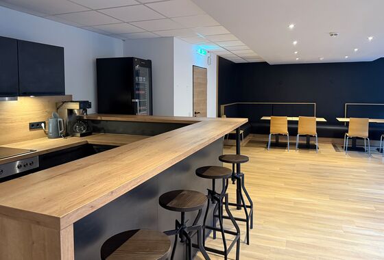 Küchentheke und Getränkekühlschrank mit vielen Sitzplätzen und Tischen