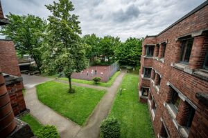 Innenhof mit Steinwegen, Wiese und Basketballplatz