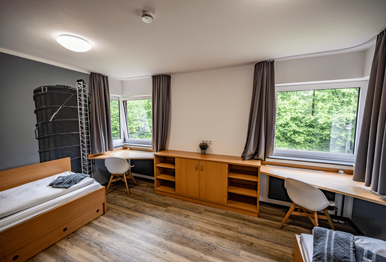 Blick in ein Zwei-Bett-Komfortzimmer mit zwei Schreibtischen und zwei Betten