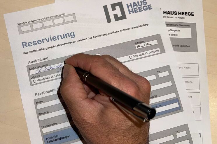 Ausfüllen des Anmeldungsformulars mit einem Kugelschreiber