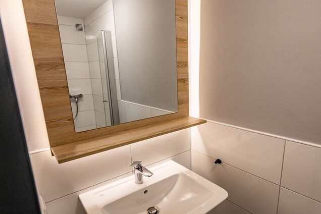 Blick auf Spiegel, Waschbecken und Dusche im Komfortzimmer