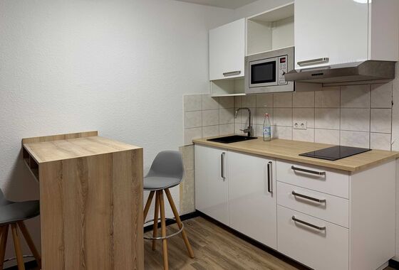 Küchenzeile im Apartmens mit Herd, Mikrowelle, Waschbecken und Esstisch